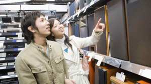 couple point at speakers in shop