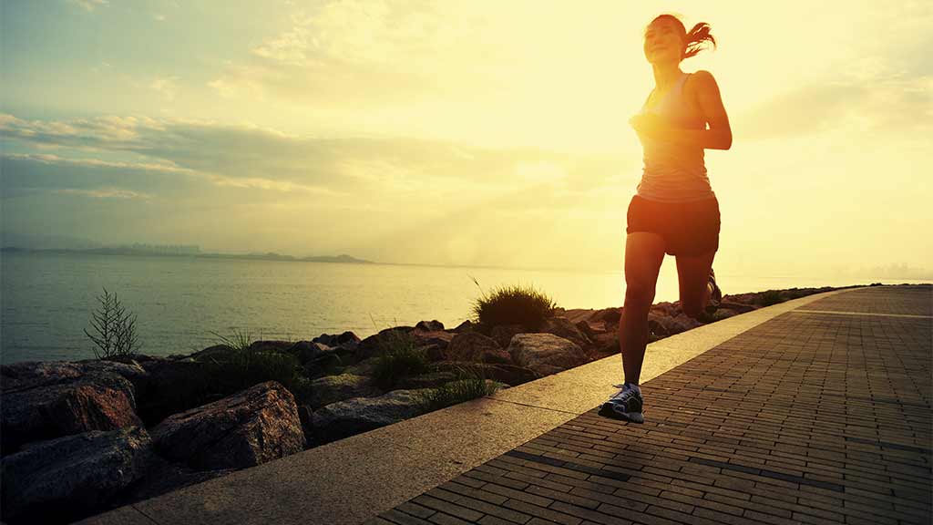 woman running at sunrise sunset