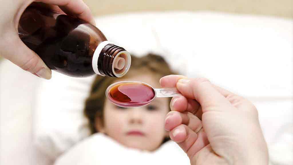 child receiving painkiller syrup