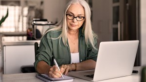 person recording digital assets on notepad