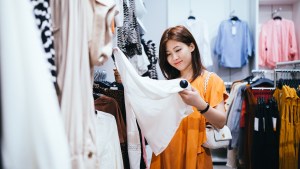 woman looks at price tag on shirt