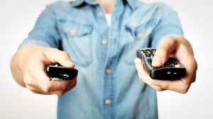 man pointing remotes at screen tv reliability