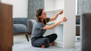 woman putting together a bookshelf