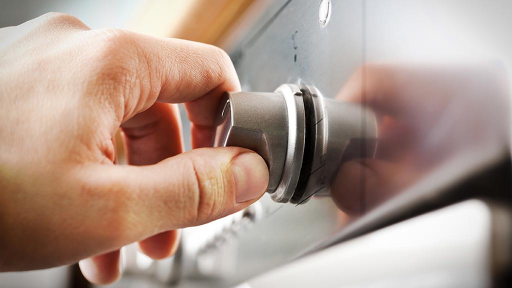 hand turning dial on oven