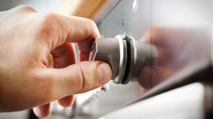 hand turning dial on oven