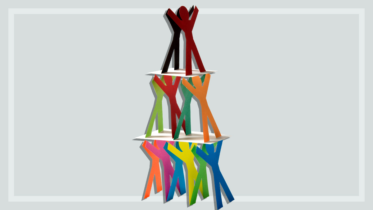 small paper figures stacked into unstable pyramid