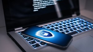 laptop and smartphone with security shield on screen