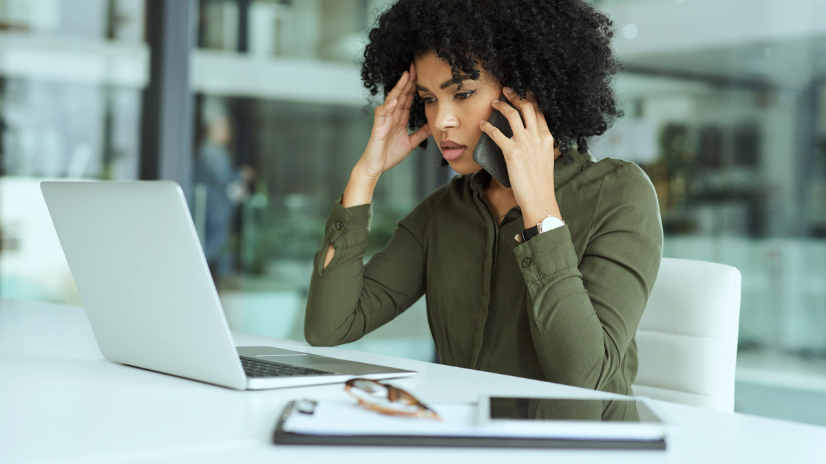 woman_on_phone_at_laptop_concerned