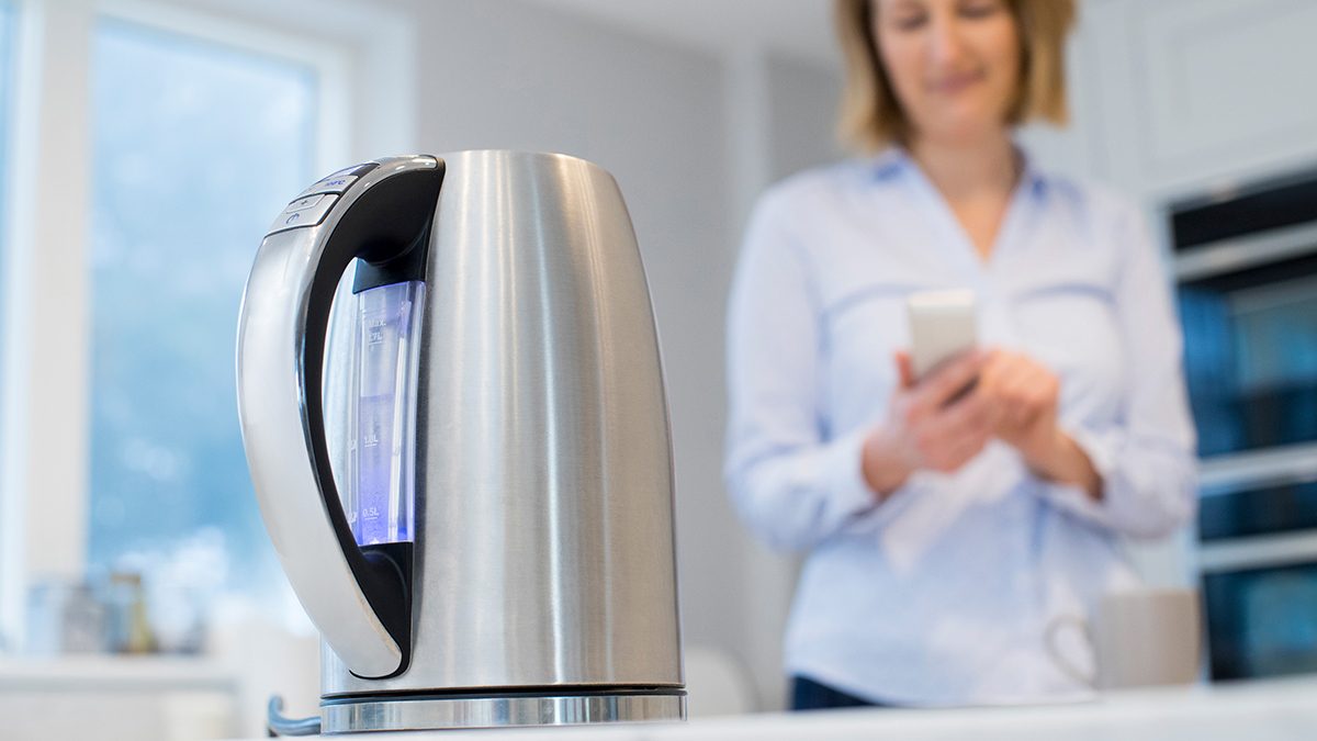 person heating water in a kettle