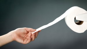 hand pulling toilet paper
