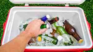 Hand taking bottle from ice filled cooler