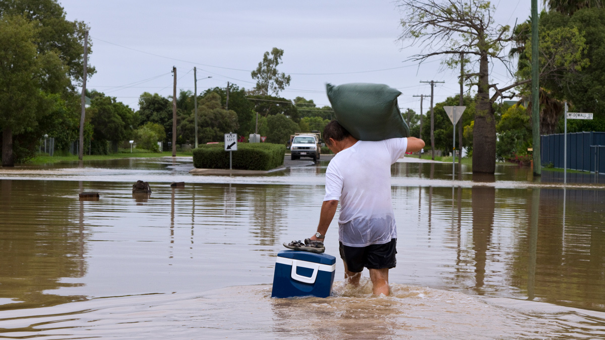 man_wading_through_flood_waters