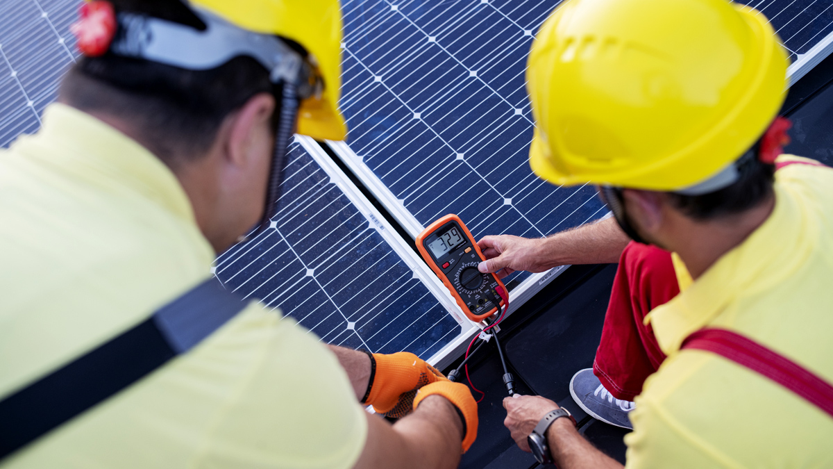 Two technicians testing a solar panel