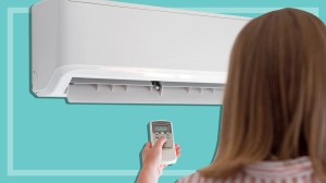 woman using an air conditioner on a teal background