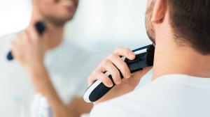 man using electric shaver HWT