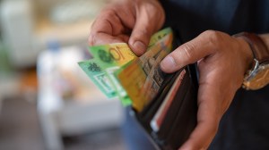 person taking australian banknotes out of wallet