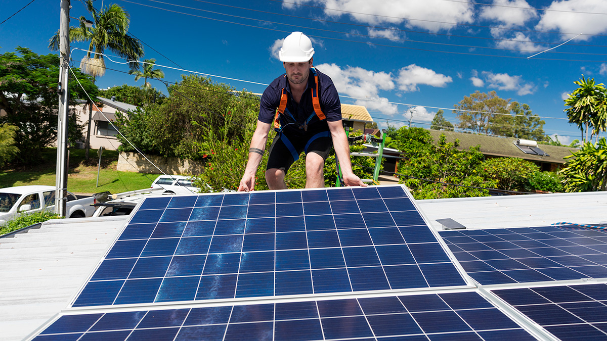 solar panel technician installing panel on australian home