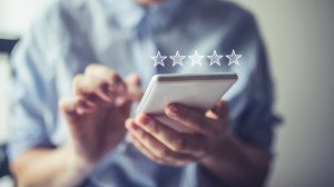 five white stars superimposed over a person holding a smartphone