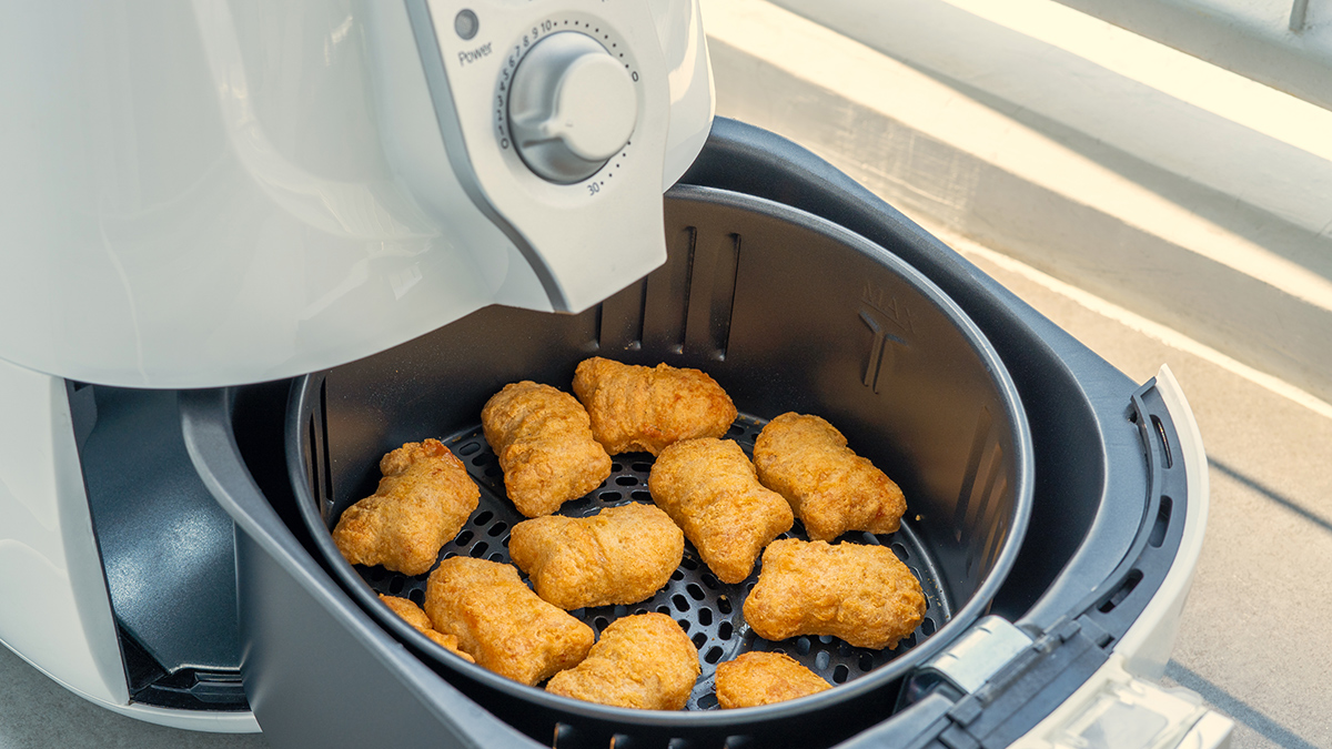 open air fryer showing chicken nuggests in the basket