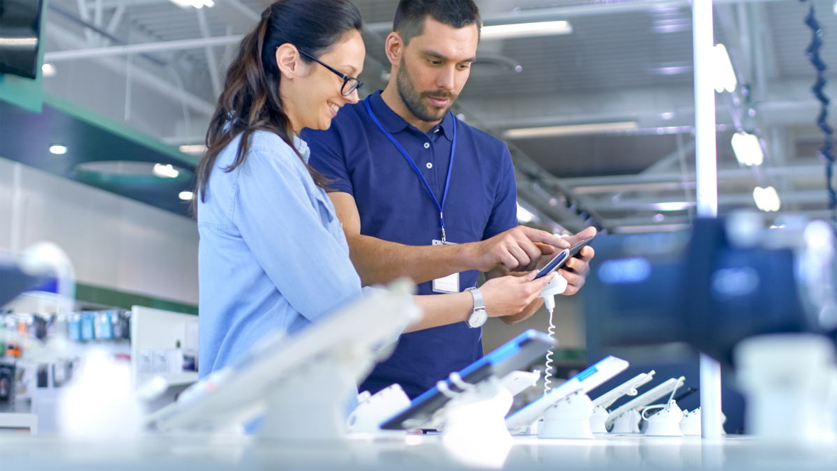 woman buying phone instore with a sales person