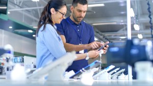 woman buying phone instore with a sales person